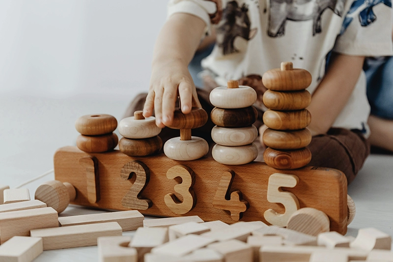 Picture of a child playing with stackable cubes in a classroom